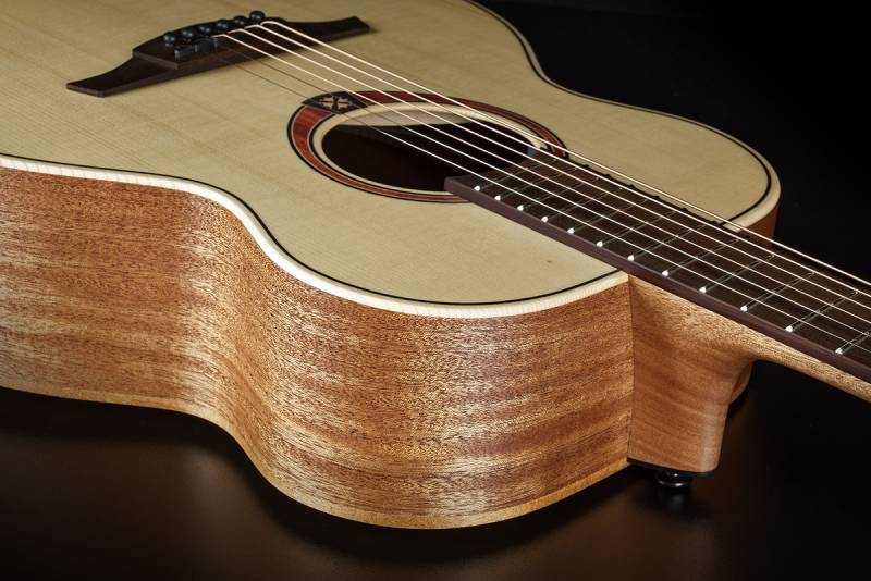 ue rapprochée de la caisse d’une guitare folk LÂG Tramontane 70 avec table claire et éclisses en bois naturel